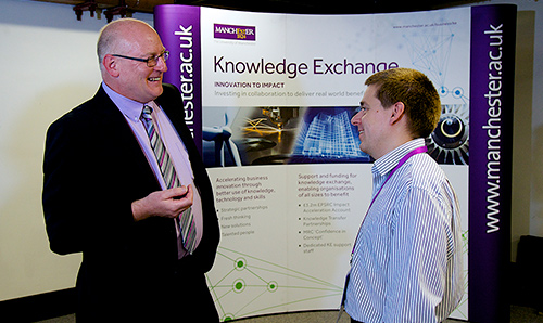 Suited men in conversation at 'Knowledge Exchange' event