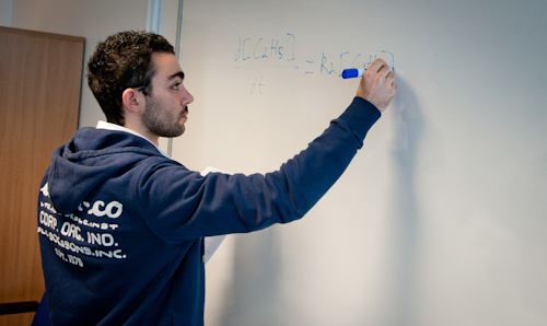 A researcher writing a formula on a whiteboard