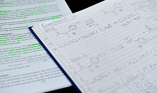 A close-up of chemistry formulas and workings on a notepad