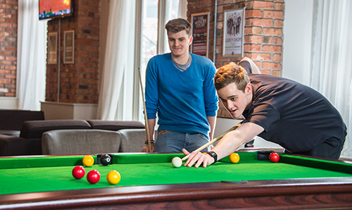 Two male student playing pool in the students' union