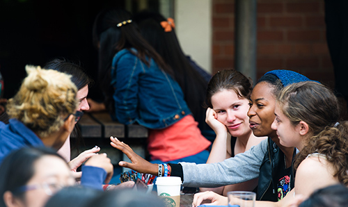 A group of female students sat on benches in discussion