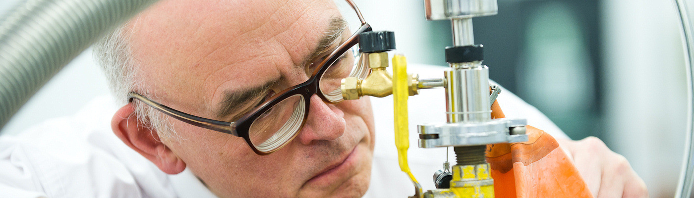 Professor looking closely at equipment