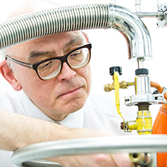 A researcher in glasses using equipment in the facility