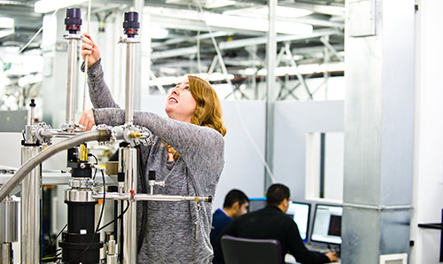 A female researcher looking up at equipment in the EPR facility