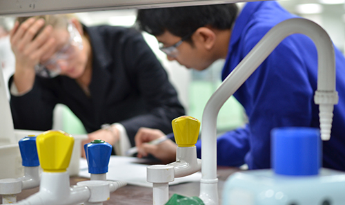 Two students discussing something on lab surface